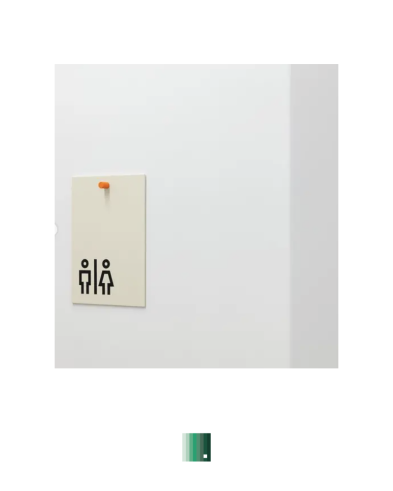 A restroom sign with male and female figure icons on a wall